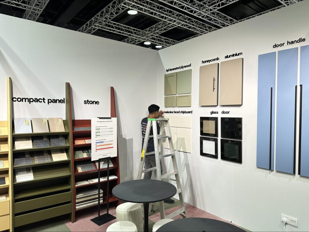 Visitors exploring a modern kitchen cabinet display and speaking with design representatives at Nest Butler HOMEDEC APR 2026