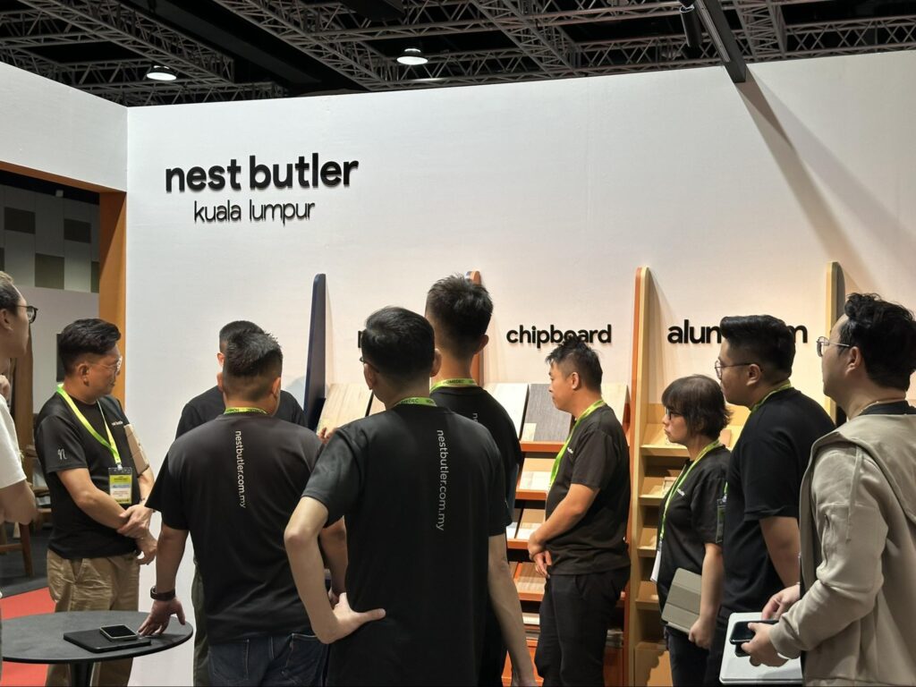 Nest Butler team gathered beside cabinetry material displays at HOMEDEC APR 2026. 